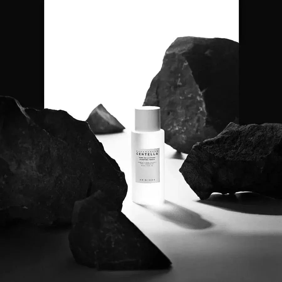 SKIN1004 Madagascar Centella brightening toner in a clear bottle with a white cap, featuring botanical design on the label.