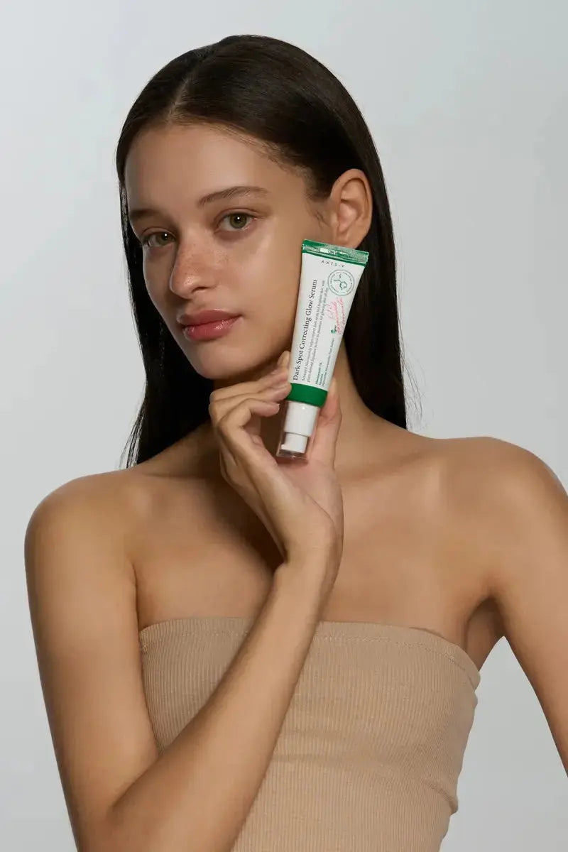 AXIS-Y Dark Spot Correcting Glow Serum in 50 ml bottle with dropper applicator, designed to improve skin radiance and reduce dark spots.
