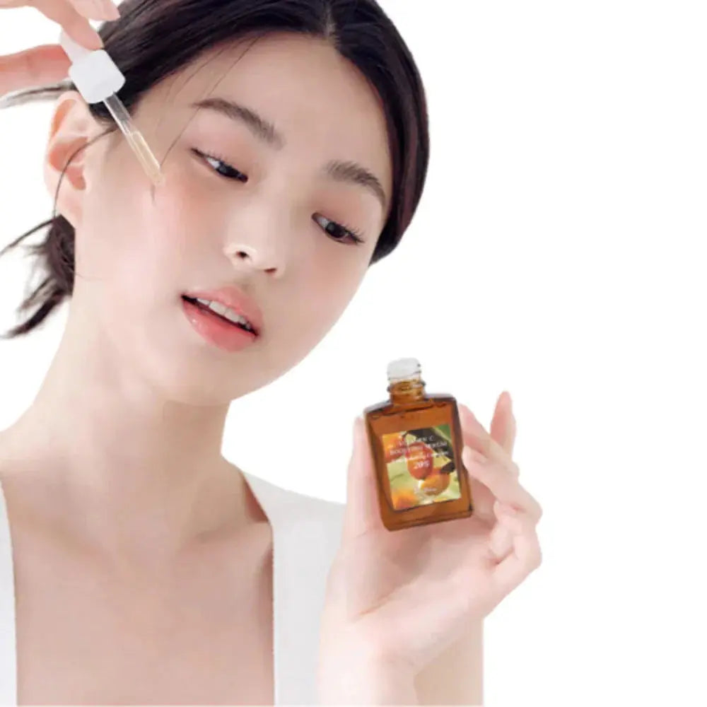 Dr Althea Vitamin C Boosting Serum in a clear bottle with a dropper, showcasing its bright, citrus-inspired packaging.